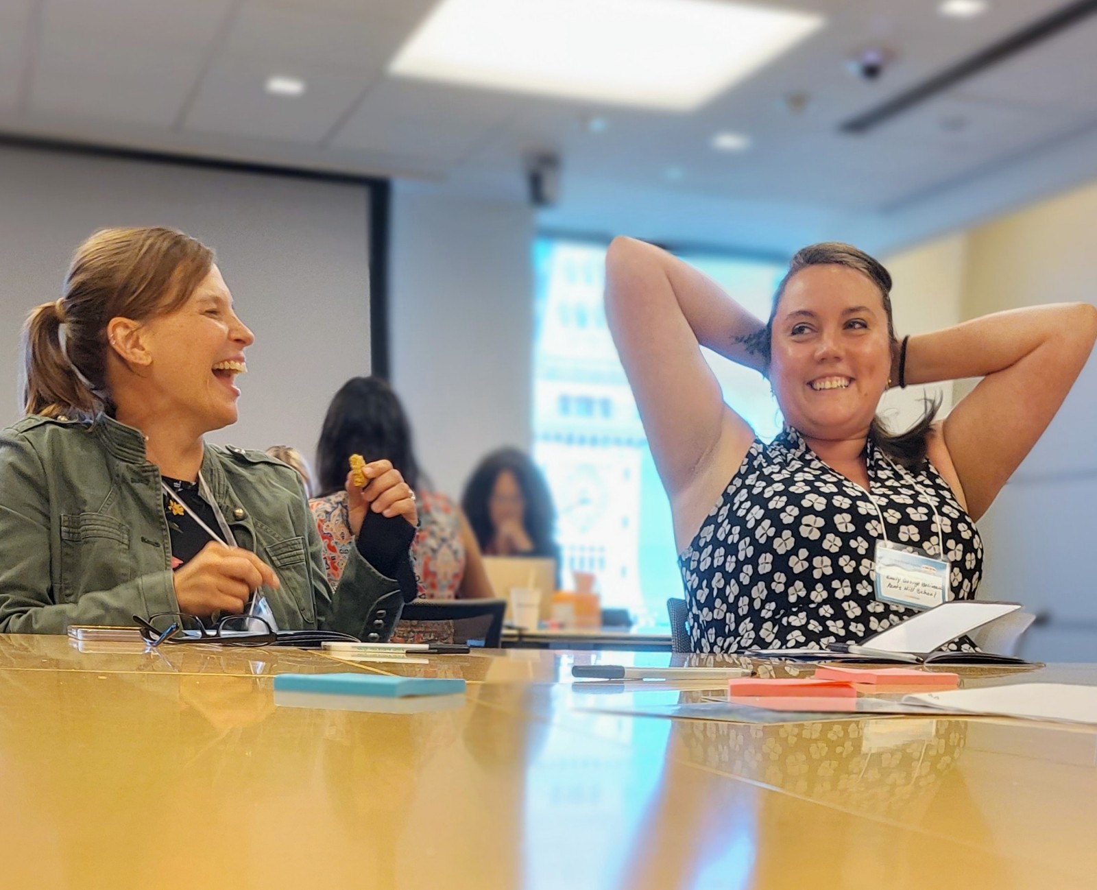Two women collaborating and laughing at GiveCampus Partner Success Days session.